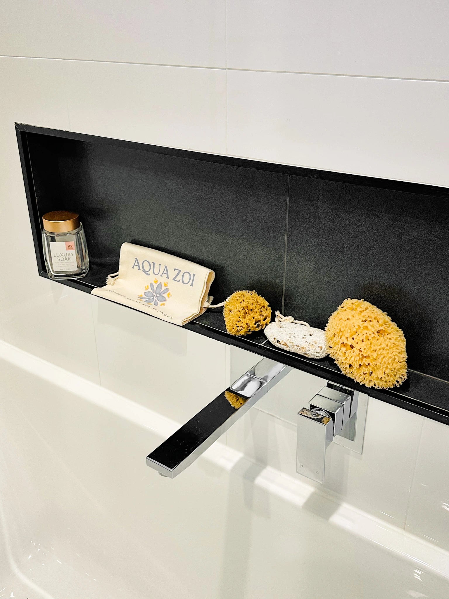 Bathroom shelf containing natural sea sponges and pumice stone.