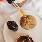 natural sea sponge on a dish with skin care dropper
