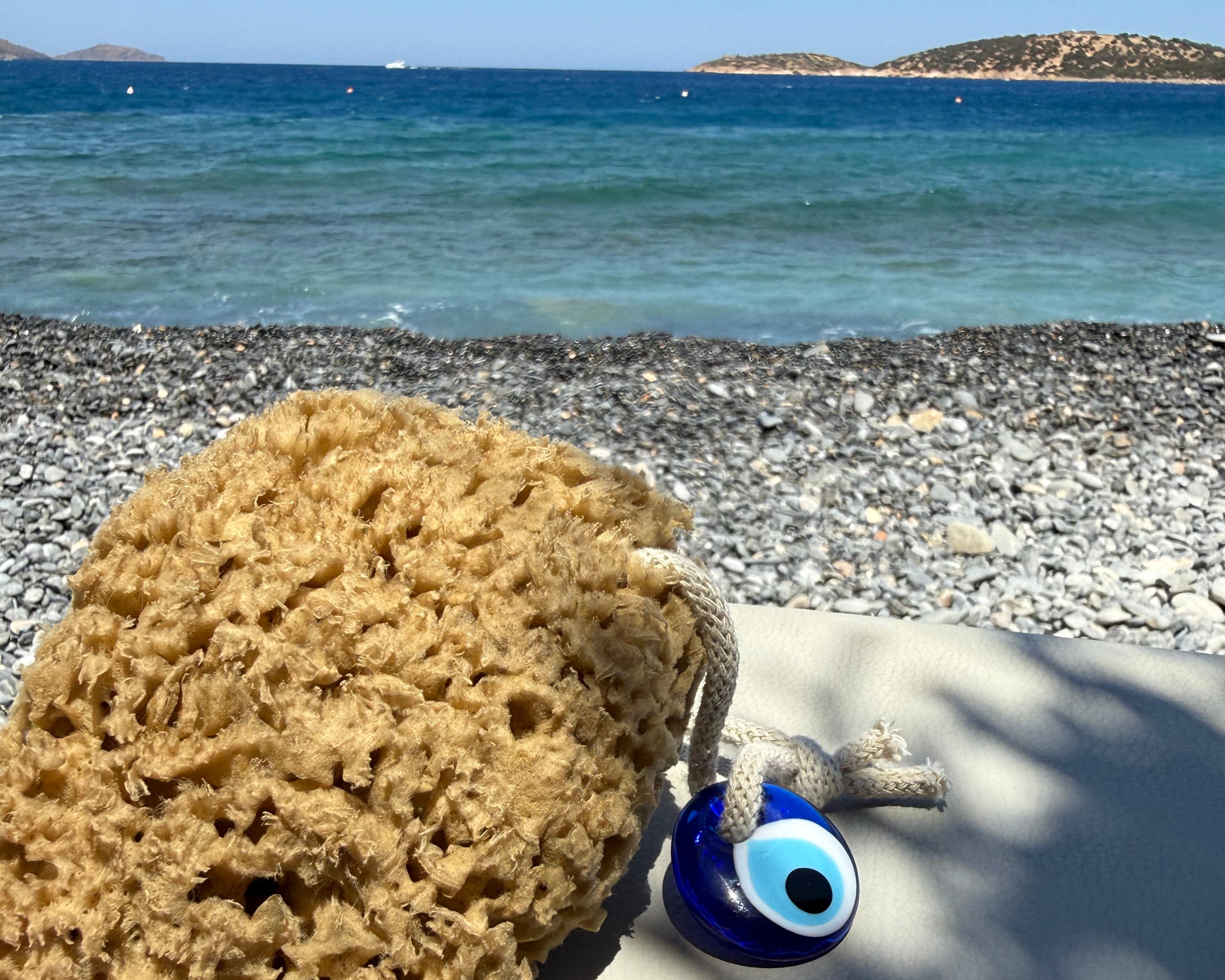 a sea sponge resting on a beach chair by the sea in Agios Nikolas