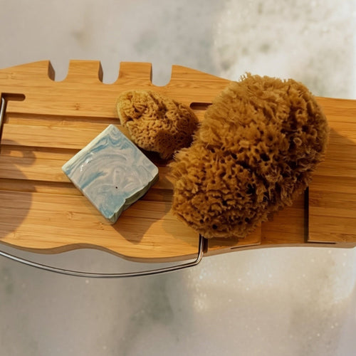 Natural Wild Sea sponge beside handmade soap and wooden bathing accessories